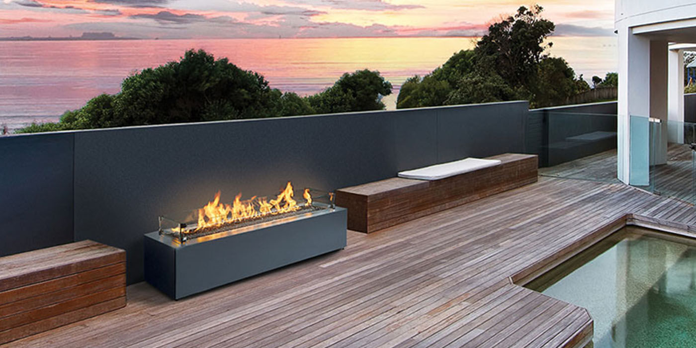 An outdoor deck with the Complete Linear Gas Fire Pit by Fire Garden
