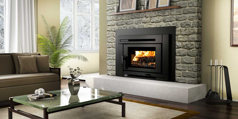 A traditional living room with a natural stone fireplace, upgraded with a wood burning stove insert