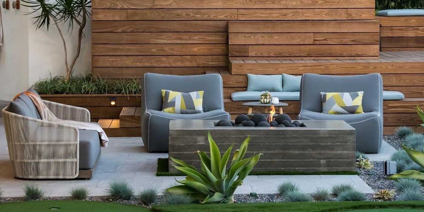 A linear gas fire pit with large, ceramic fire bals