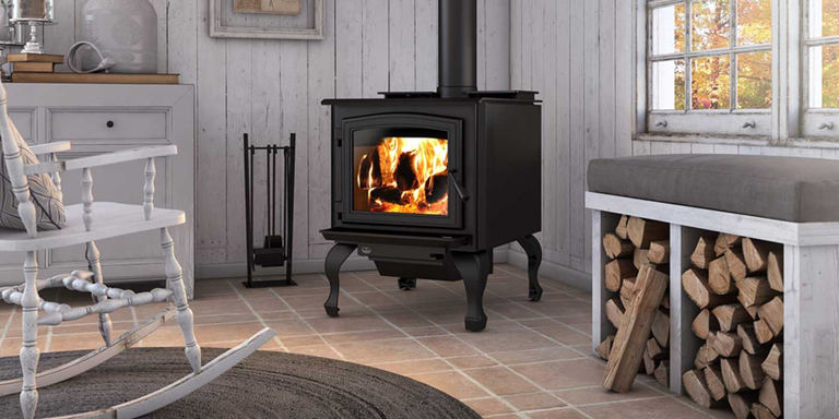 A rustic living room with a traditional wood burning stove and wood storage area