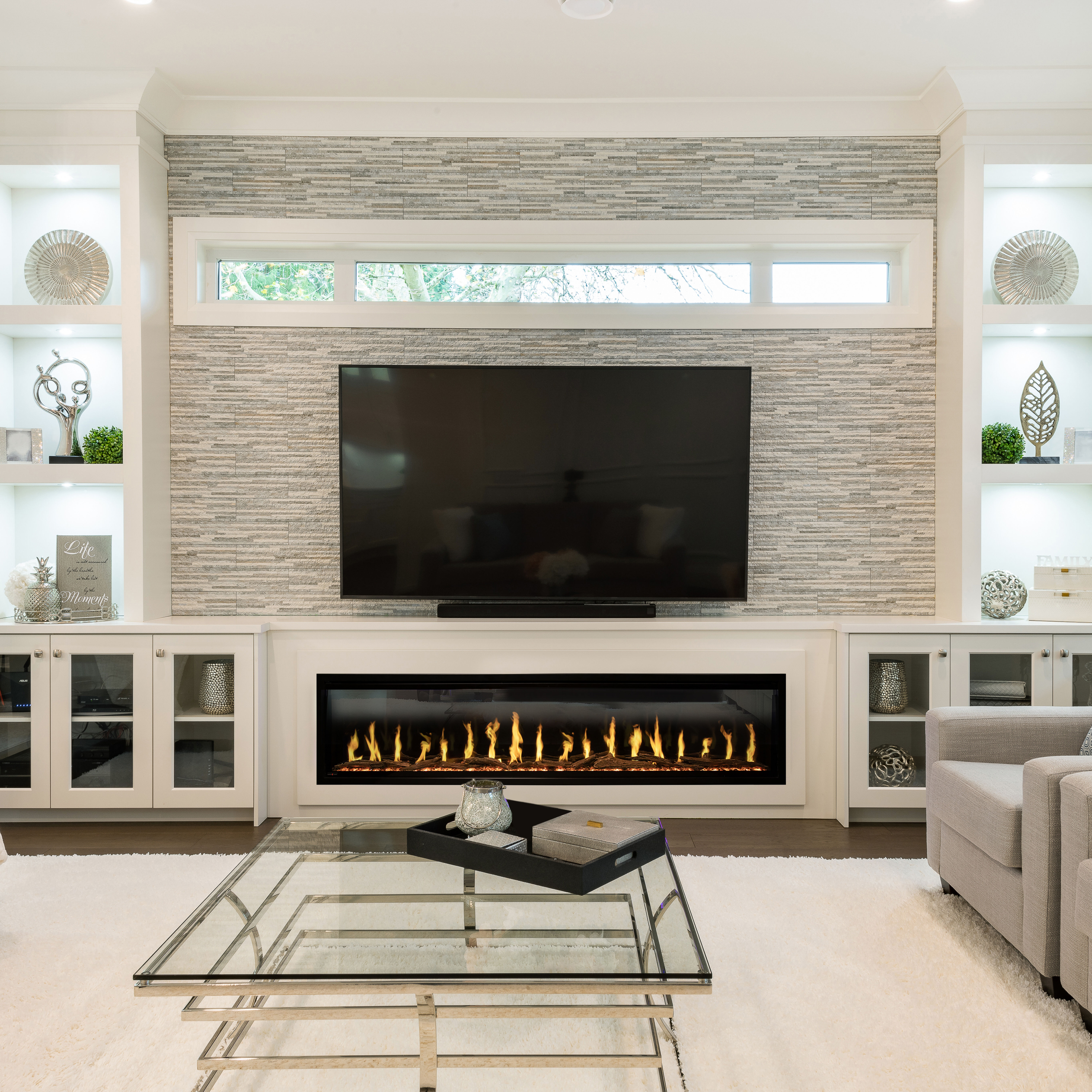 The Modern Flames Orion Slim electric fireplace installed into a custom entertainment center with shelves, underneath a large TV. 