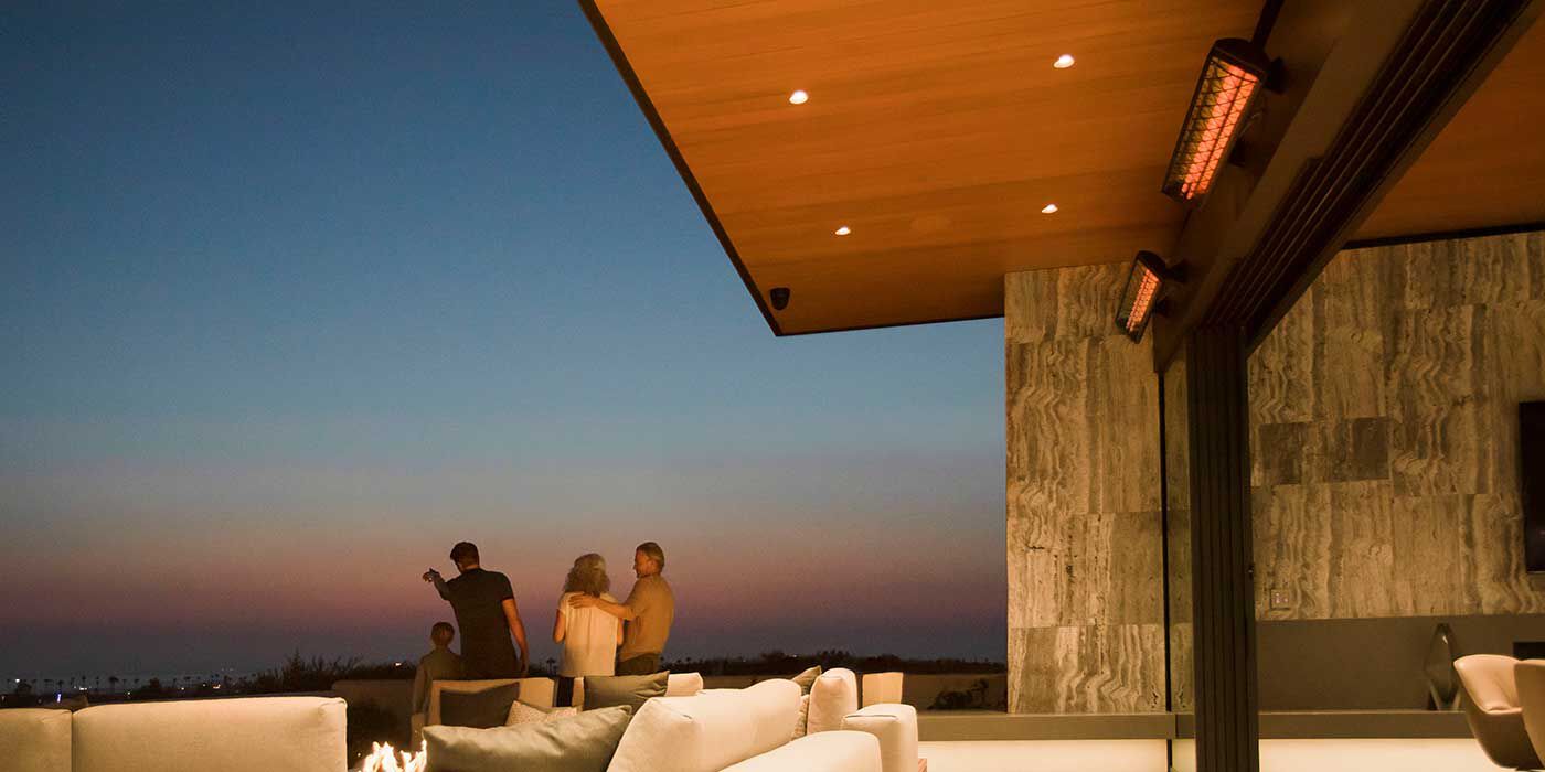 An outdoor patio space with a lounge area and two gas patio heaters installed on the ceiling 