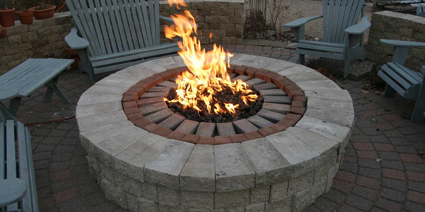 A custom-built gas fire pit finished with brick pavers and an installation collar to help create a snug fit.