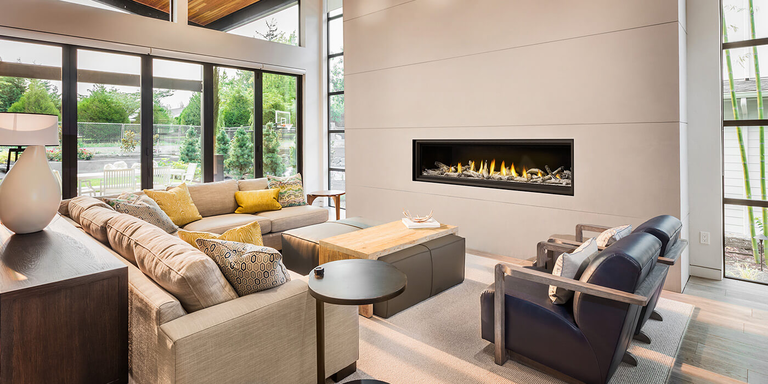 A contemporary indoor living room with a linear gas fireplace and realistic Driftwood-style gas logs