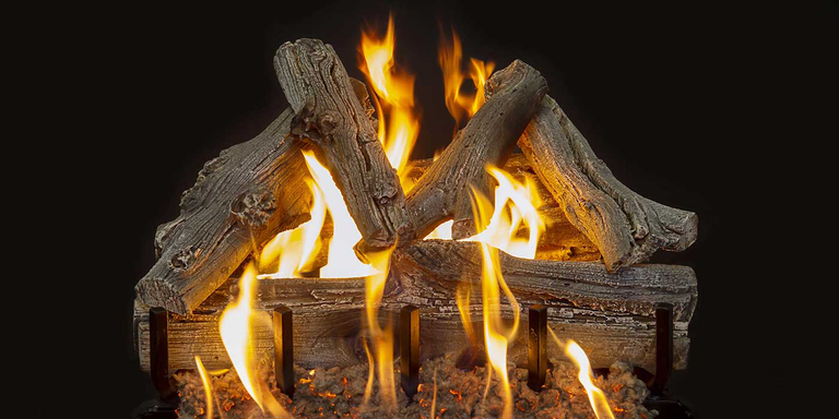 A Vented gas log set with a rustic, detailed brown-gray bark finish, black lava rock in the media bed, and yellow flames.
