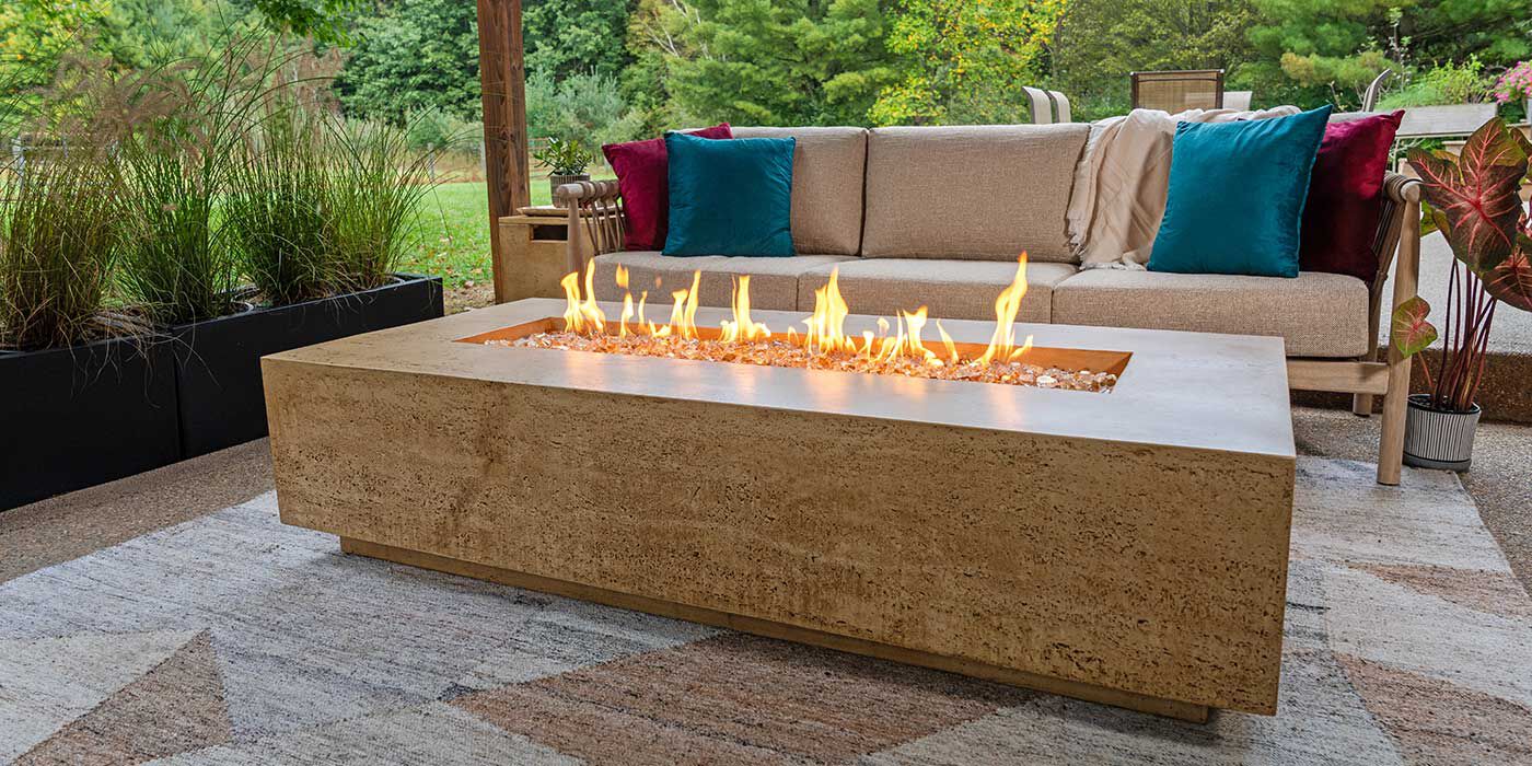 The Tuscan Gas Fire Pit by FlameCraft on an outdoor patio 