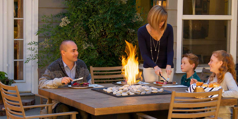 An outdoor gas fire pit dining table with multi-colored firestones 