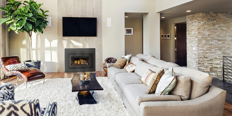 A luxurious, contemporary indoor living room with a built-in gas fireplace and a TV mounted above it