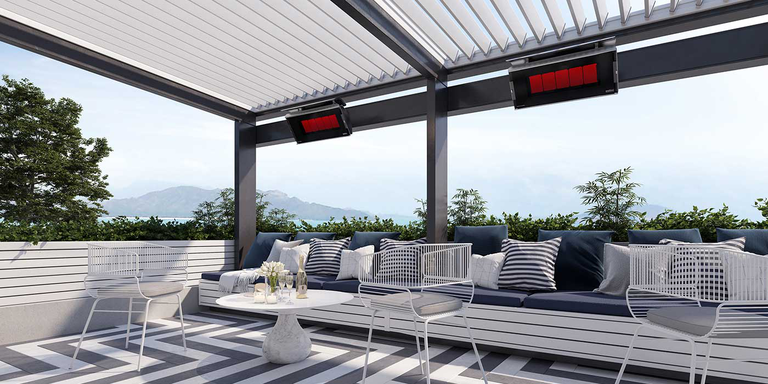 A contemporary outdoor living room with a large sectional couch and two Bromic Natural Gas patio heaters installed on the ceiling 
