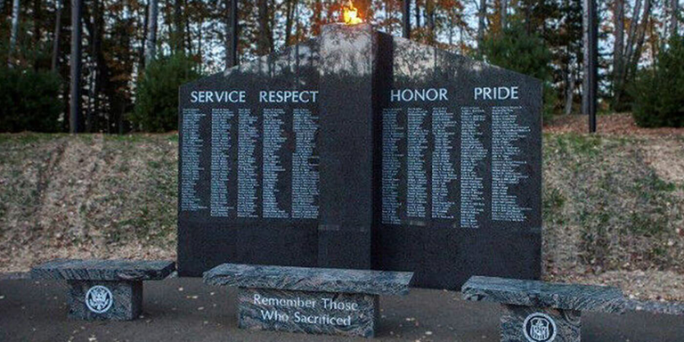 Large dark gray ganite veteran memorial in the woods