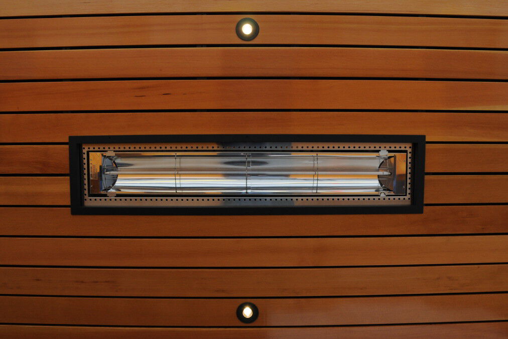 A close-up view of a stainless steel, linear patio heater with two heating elements, installed on a wooden plank wall.