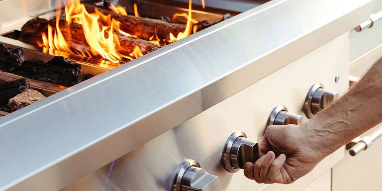 A man pre-heating a charcoal grill 