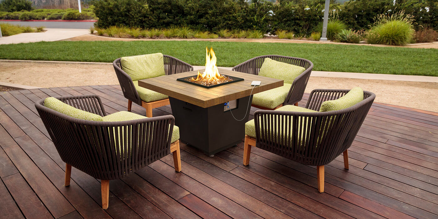 The Cosmo fire pit table from American Fyre Designs placed on an outdoor deck  The Cosmo fire pit table from American Fyre Designs placed on an outdoor deck