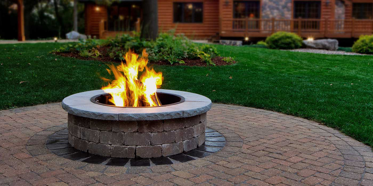 A custom, DIY gas fire pit made of concrete and masonry blocks