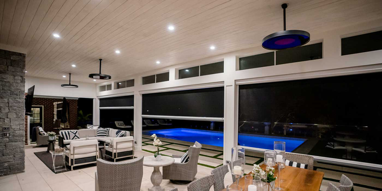 A semi-enclosed outdoor living space with three Bromic Eclipse patio heaters installed on the ceiling 