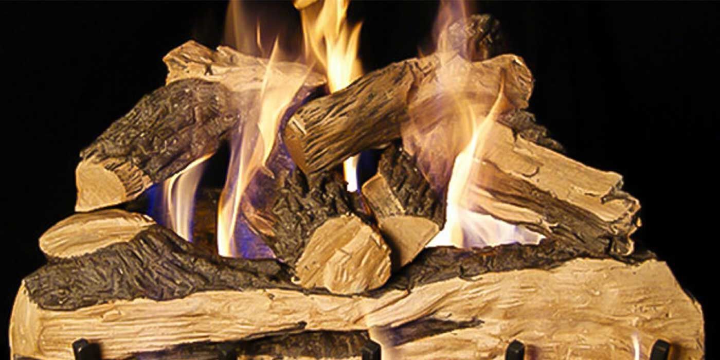 A stack of Vented Oak-style gas logs with natural splitting on a black background. 