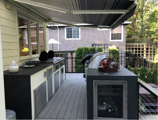 Gray and white outdoor kitchen island with stainless steel components and a built-in grill