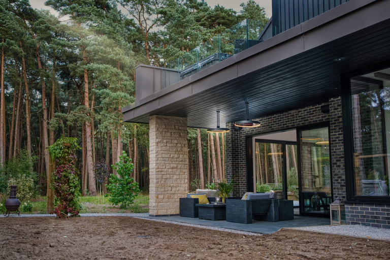 A luxury home with a large outdoor patio and two Bromic Eclipse pendant style patio heaters installed on the ceiling.