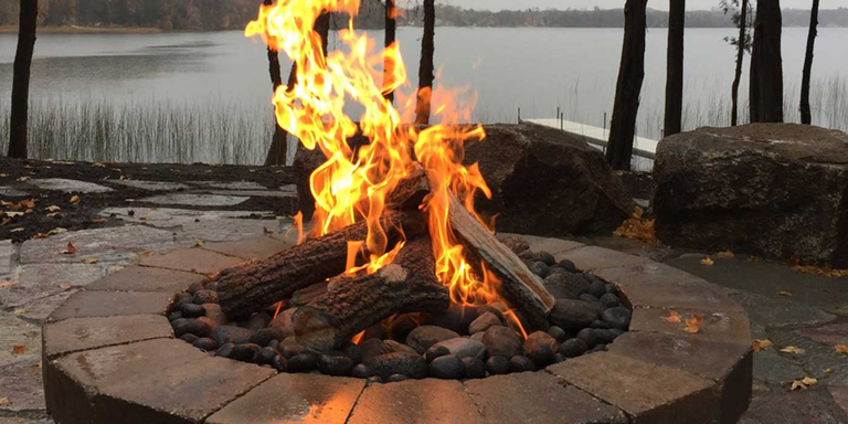 An outdoor gas fire pit with gas logs and an HPC Torpedo burner system