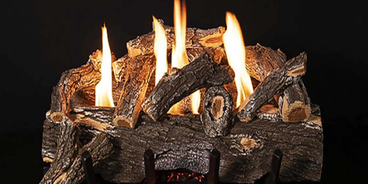 A weathered Ventless gas log set with tall, yellow flames, lava rock, and glowing embers on a black fireplace grate.