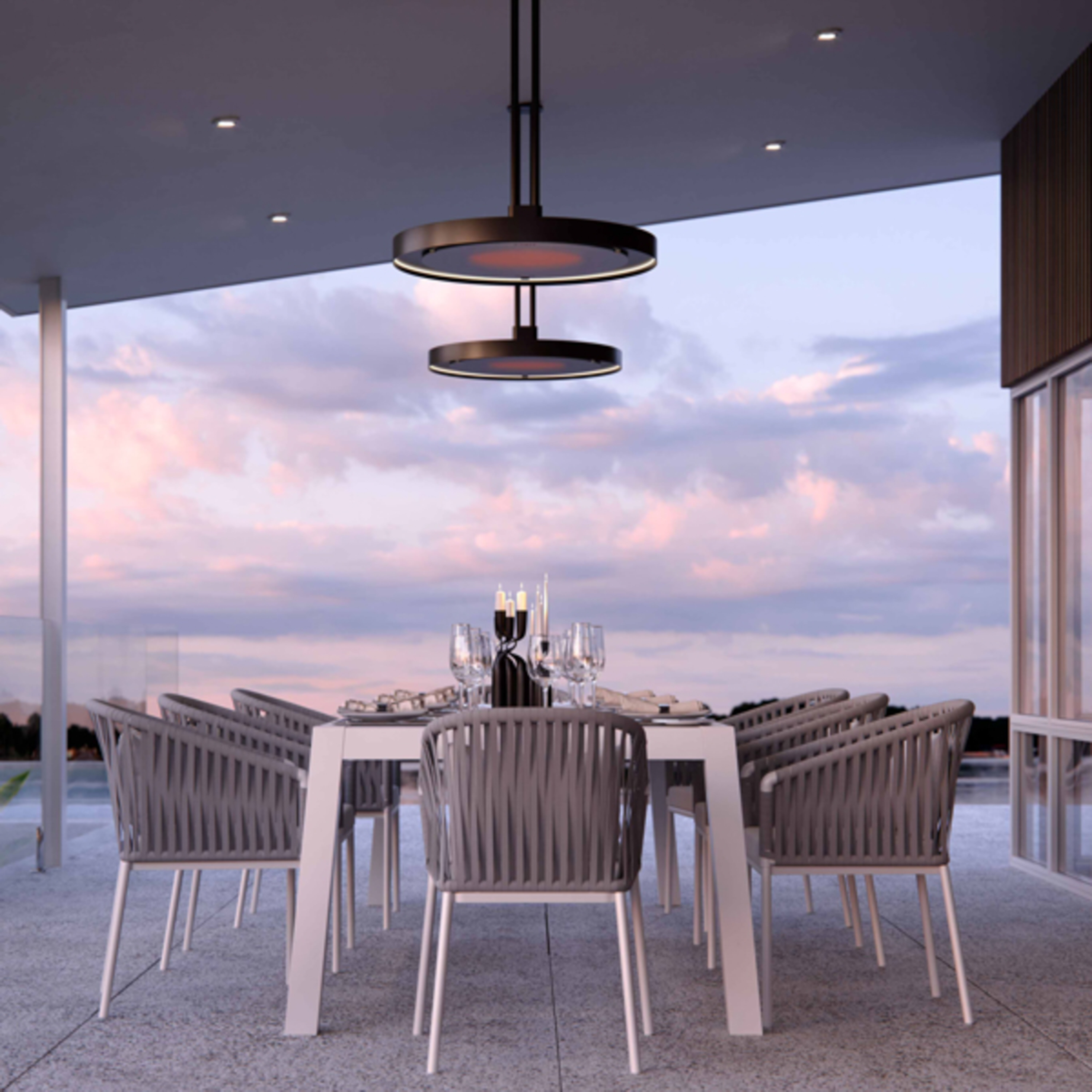 The Bromic Eclipse Smart-Heat Pendant Electric Patio Heater installed in an enclosed patio space underneath a large white dining table with eight chairs.