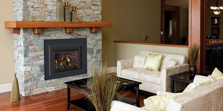 A contemporary living room with two white couches and a custom natural stone hearth with a square gas fireplace insert and log set.