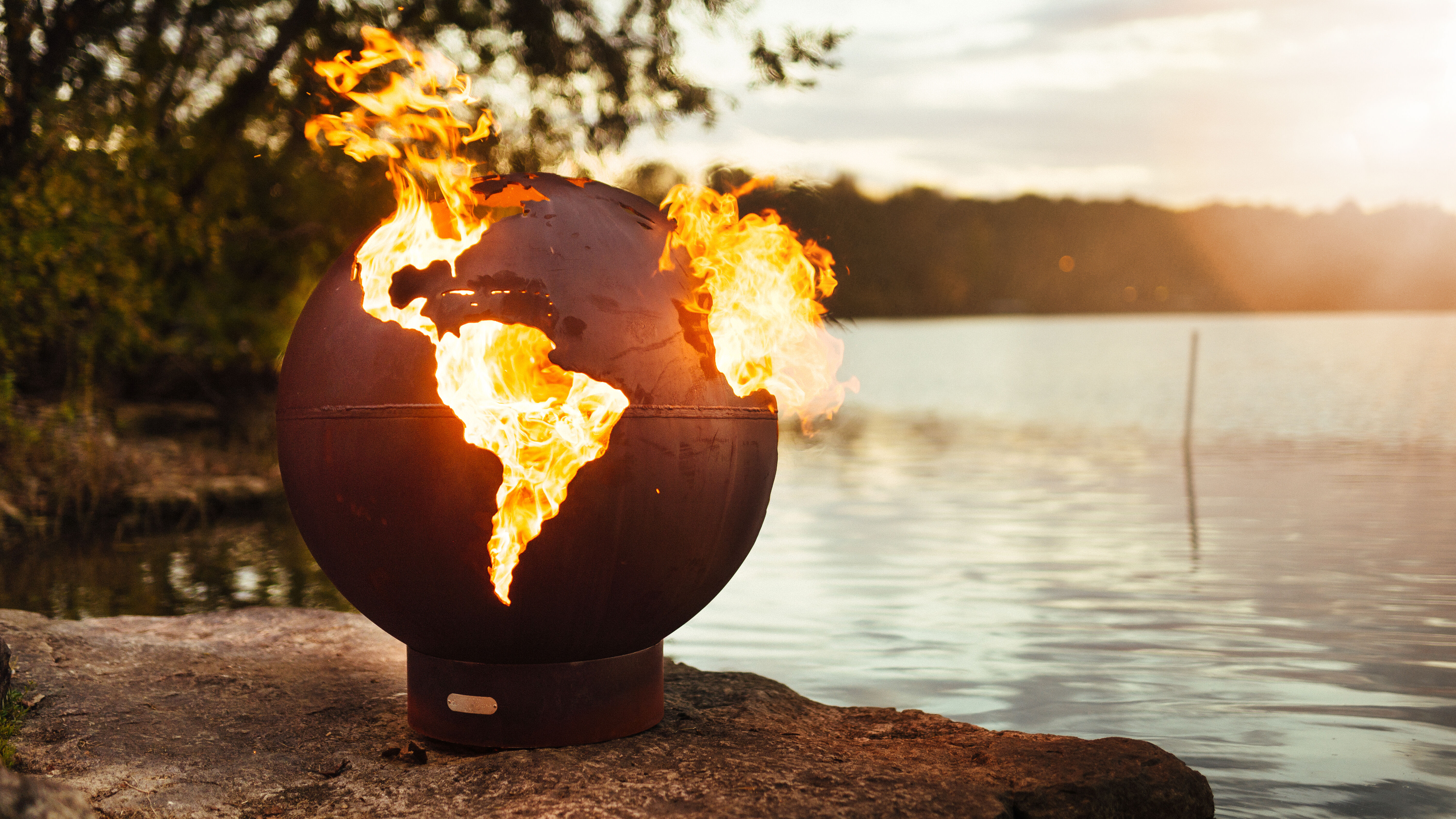 A steel wood burning gas fire pit that is shaped like a globe, with cutouts for each continent, so the flames can poke through.