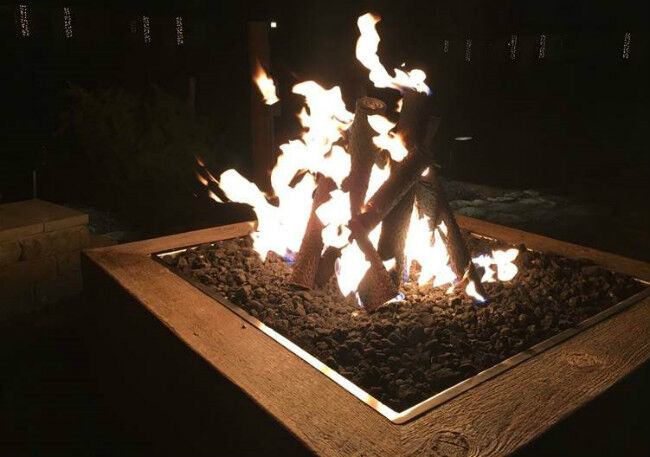 Close-up of gas logs burning on a gas fire pit at nighttime