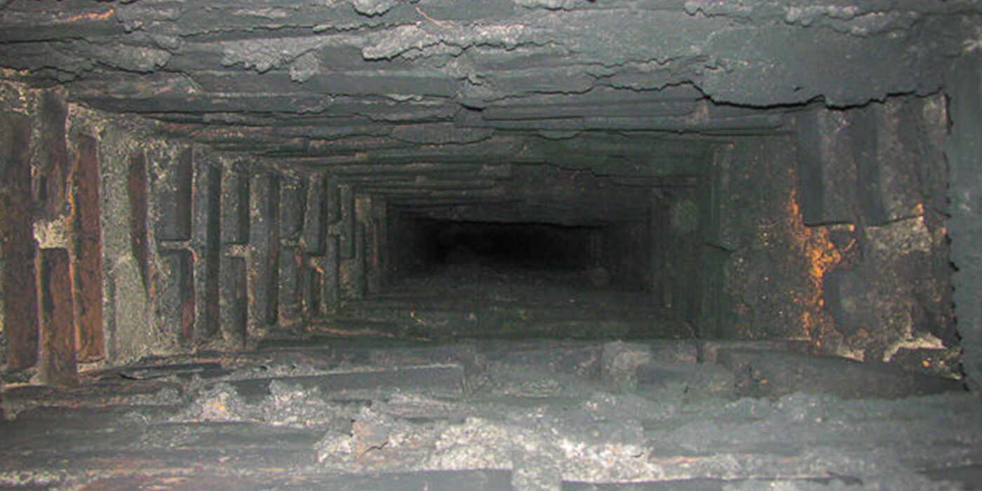 Black creosote residue inside a red brick chimney