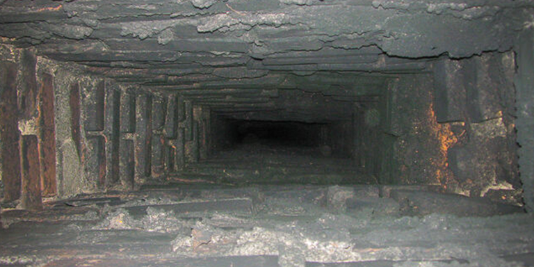 Black creosote residue inside a red brick chimney