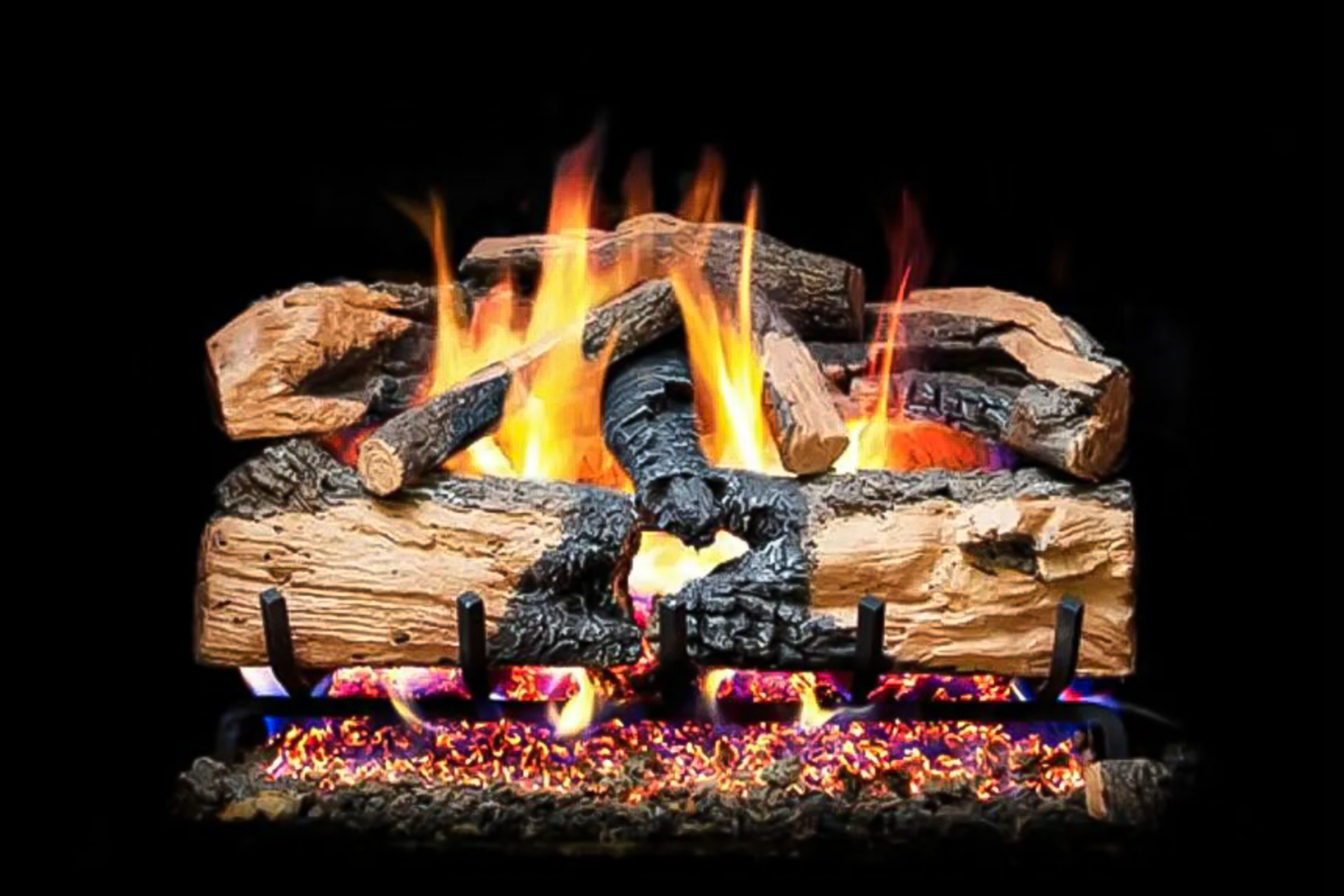 A Ventless gas log set with natural splitting, and a charred bark finish on a black background. 