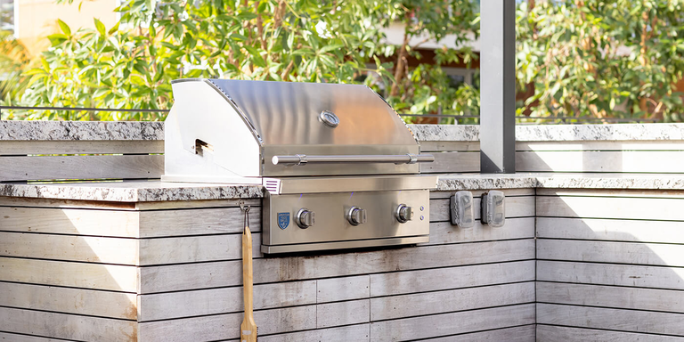 An outdoor grilling station with a stainless steel built-in grill.