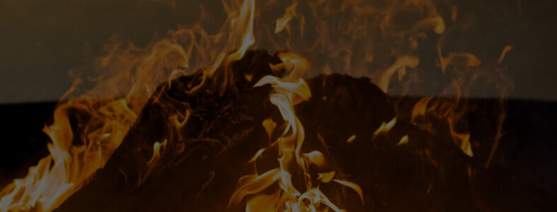 A close-up view of burning orange flames with a black overlay and Fire Pit Art's logo.