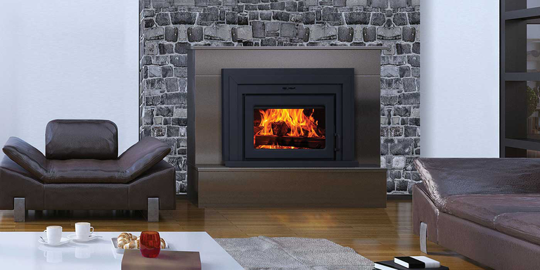 A modern indoor living room with a natural stone fireplace, upgraded with a wood burning stove insert