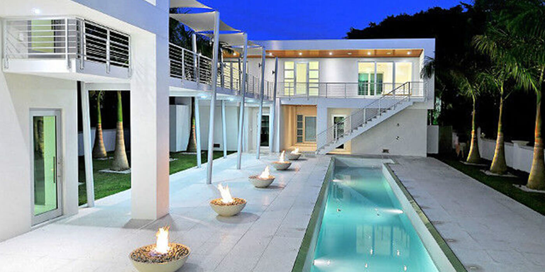Outdoor patio with a swimming pool and five gas fire bowls at an ultramodern luxury home
