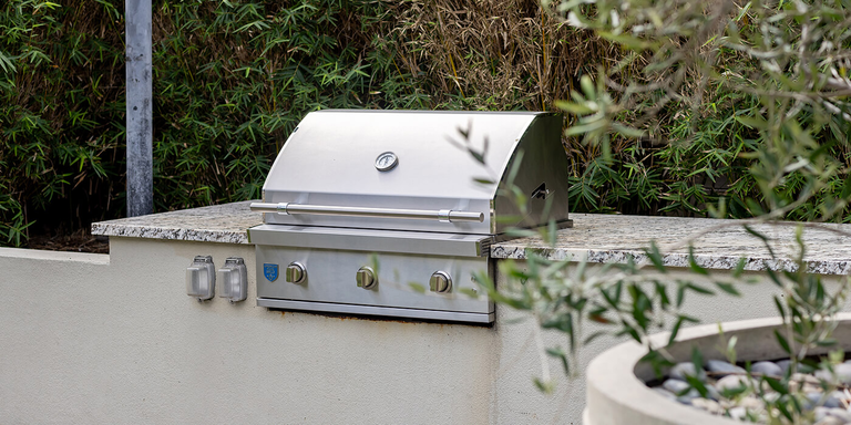 A stainless steel grill from American Made Grills installed on an outdoor kitchen island