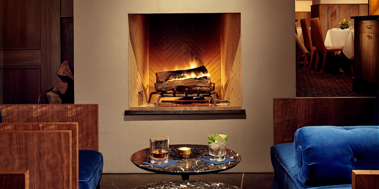 A classic, square-shaped wood burning fireplace in a lounge area