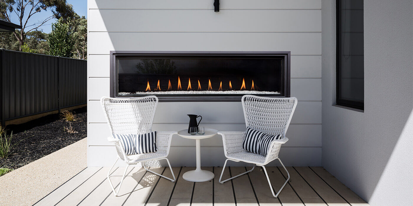 A modern linear gas fireplace installed on an outdoor patio