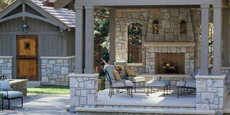 Covered outdoor living room with masonry fireplace adjacent to swimming pool