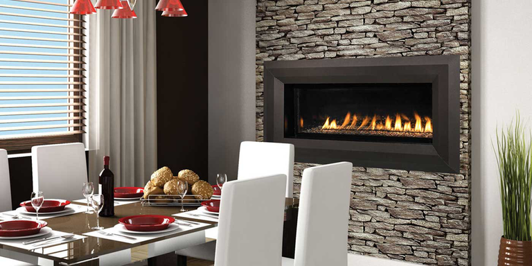 A traditional dining room with a large natural stone hearth and a linear, Ventless gas fireplace