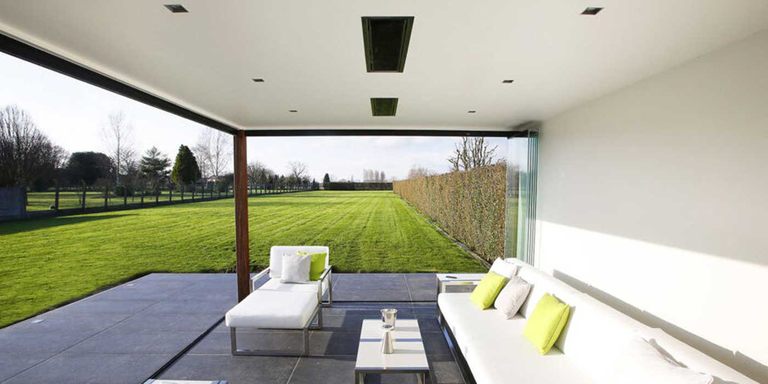 An outdoor seating area with two electric patio heaters recessed into the ceiling 