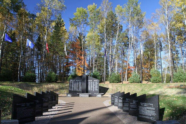 Pathway to gray granite veteran memorial in the woods