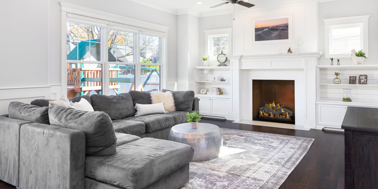 A contemporary living room with a traditional, square fireplace and a realistic gas log set