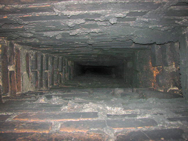 Black creosote residue inside a red brick chimney