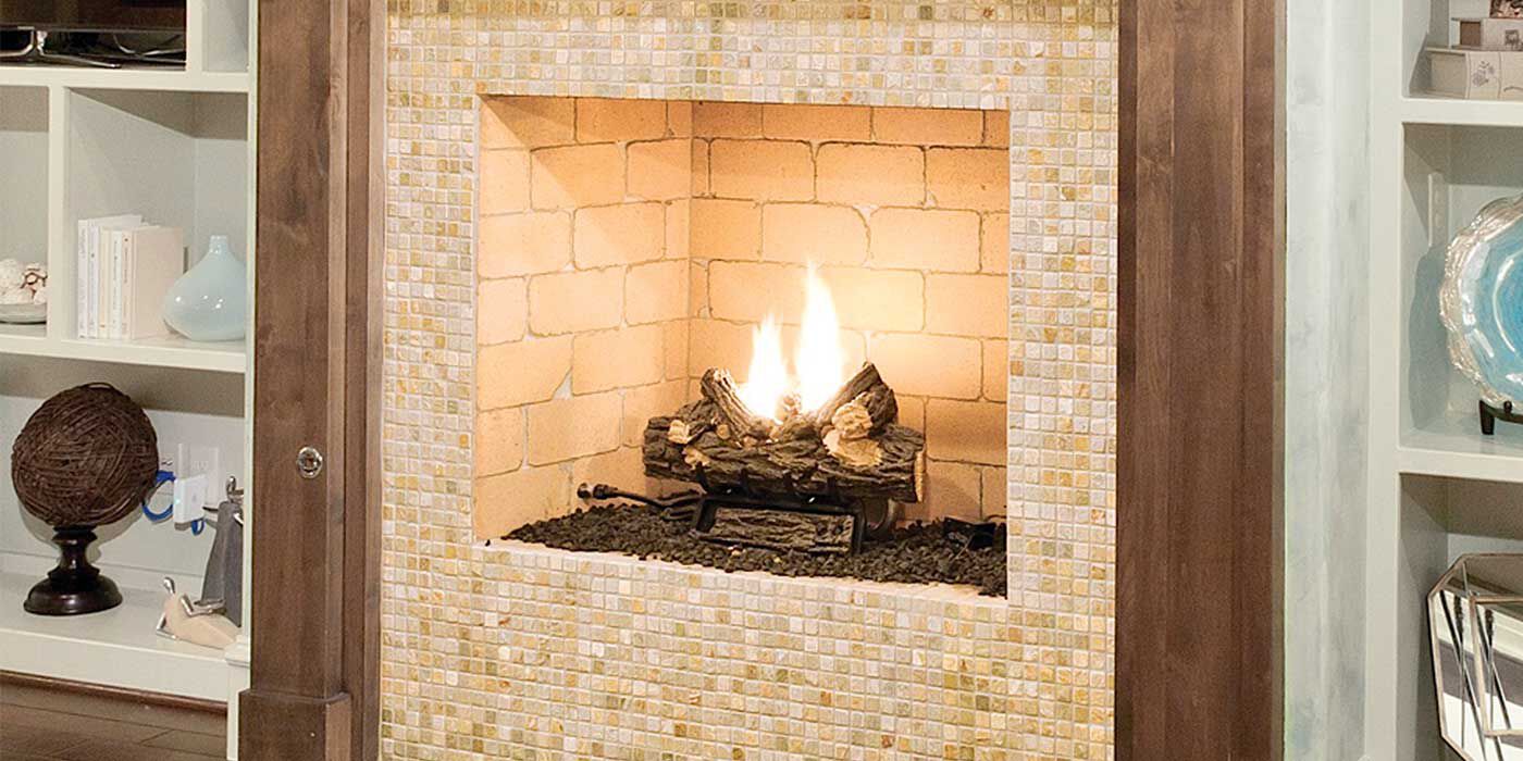 A Standard Isokern fireplace with a brick firebox and a multi-colored beige tile exterior finish.