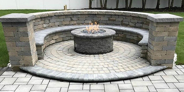 Masonry fire pit in the middle of a stone patio