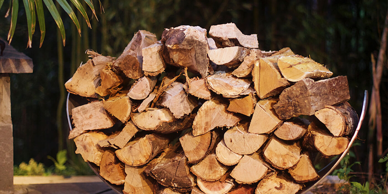A large, crescent-shaped steel firewood rack 