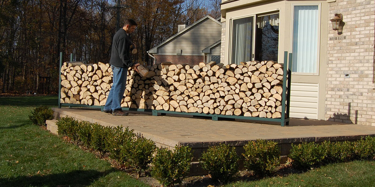 An extra-large Woodhaven firewood rack stocked with wood logs