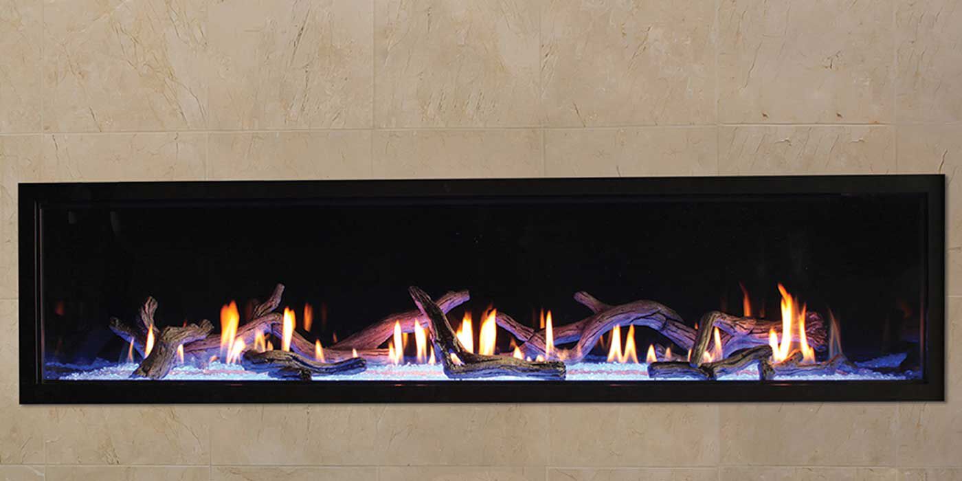 A linear gas fireplace with blue and orange flames and a Driftwood log set
