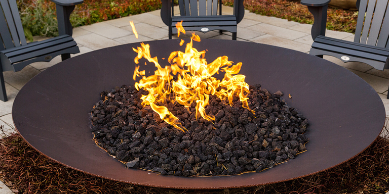 A large round gas fire bowl with a round fire pit burner 